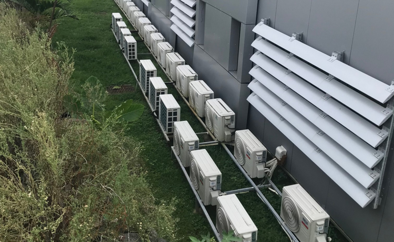 Mauvaise conception d’une installation de climatiseurs : les appareils du premier rang reçoivent le flux d’air chaud de ceux du deuxième rang, dégradant la performance énergétique globale.